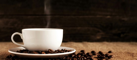 En vit kopp kaffe mot brun bakgrund