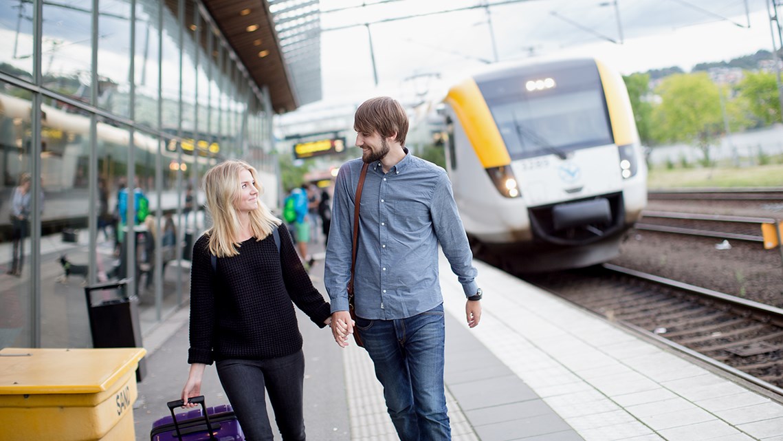 Ett par håller i handen och går längs perrongen på Jönköpings centralstation